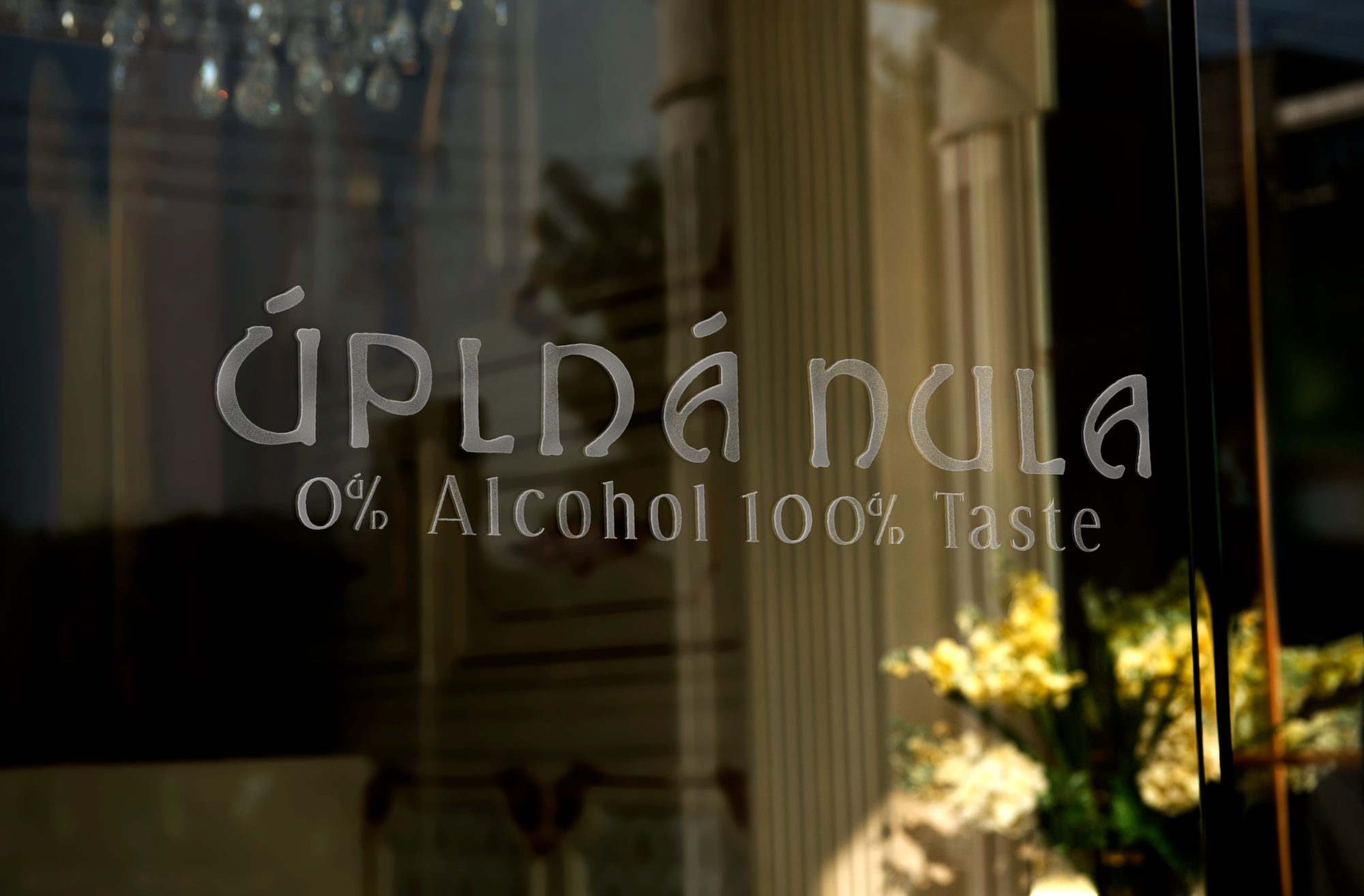 Úplná Nula logo etched onto the venue's window glass.